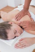 Fisioterapista che fa massaggio del braccio al suo paziente foto