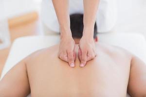 Fisioterapista che fa massaggio alla schiena al suo paziente