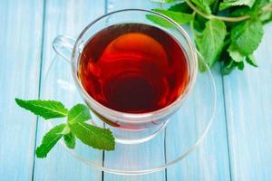 tazza di tè nero con foglie di menta foto