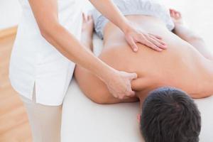 Fisioterapista che fa massaggio alla spalla al suo paziente