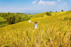 le donne asiatiche viaggiano nei campi di riso verdi sulle montagne durante le vacanze. felice e godendo di una natura meravigliosa. risaie dorate. viaggiare con una mappa di ragazze asiatiche. estate foto