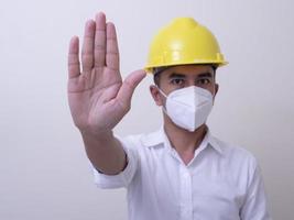 i lavoratori dell'industria asiatica indossano elmetti gialli, indossano maschere protettive per la loro salute foto