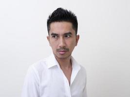 giovane uomo asiatico isolato su sfondo bianco guardando lateralmente foto