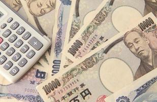 calcolatrice e banconota in yen giapponese foto