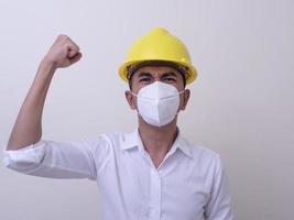 i lavoratori dell'industria asiatica indossano elmetti gialli, indossano maschere protettive per la loro salute foto