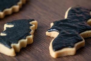 primo piano di decorare simpatici biscotti di pipistrello di Halloween con glassa. foto