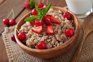 porridge di farina d'avena con frutti di bosco in una ciotola bianca foto