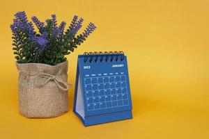 gennaio 2023 calendario da tavolo con pianta in vaso su sfondo giallo. foto
