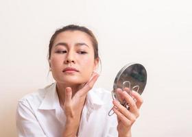 giovane donna che applica il trucco sul viso foto