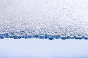 bolle che si formano sopra l'acqua nel bagnoschiuma foto