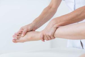 Fisioterapista che fa massaggio ai piedi foto