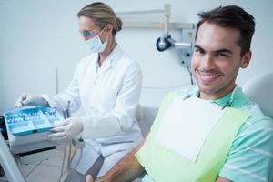 uomo sorridente in attesa di esame dentale