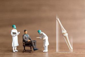 i pazienti delle persone in miniatura vengono discussi da un medico ortopedico foto