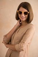 Ritratto di bella giovane donna sorridente che indossa occhiali da sole foto
