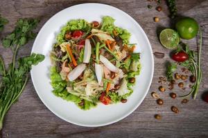 insalata tailandese con carote, pomodoro, pasta di vetro, sedano e maiale foto