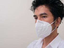 giovane asiatico in camicia bianca e maschera medica per proteggere covid-19 foto