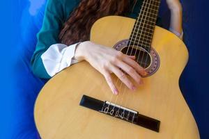 primo piano delle mani femminili che suonano la chitarra classica foto