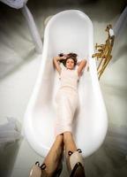 donna in abito lungo sdraiato nel lussuoso bagno foto