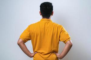 giovane uomo asiatico in piedi all'indietro distogliendo lo sguardo con le braccia sul corpo foto