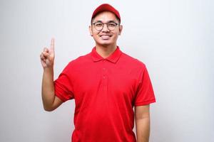 corriere asiatico che indossa l'uniforme di consegna e il cappuccio che mostra e punta verso l'alto con le dita numero dieci mentre sorride fiducioso foto