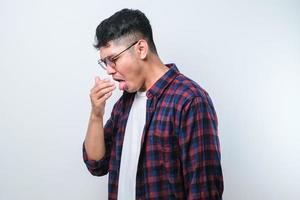giovane uomo asiatico che odora qualcosa di puzzolente e disgustoso, odore intollerabile, trattenendo il respiro con le dita sul naso. cattivo odore foto