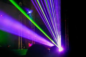 raggi al neon laser viola. folla di persone che guardano lo spettacolo laser al festival di strada. foto