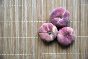 primo piano di pesche deliziose succose su una stuoia. foto