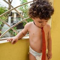 simpatico ragazzino shivaay sul balcone di casa durante l'estate, dolce servizio fotografico per ragazzino durante la luce del giorno, ragazzino che si diverte a casa durante il servizio fotografico foto