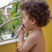 simpatico ragazzino shivaay sul balcone di casa durante l'estate, dolce servizio fotografico per ragazzino durante la luce del giorno, ragazzino che si diverte a casa durante il servizio fotografico foto