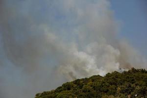 fumo di incendi boschivi sui pendii delle colline. fuoco nella foresta di montagna. incendi boschivi foto