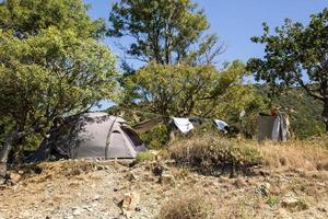 tenda d'argento nella macchia verde in una soleggiata giornata estiva nel campeggio turistico foto