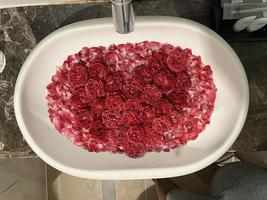 decorazione rosa per stanze dal concetto romantico. il seducente profumo delle rose. le rose sono ben disposte e decorate per formare un cuore. le camere d'albergo sono preparate per le coppie che vanno in luna di miele. foto