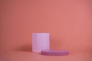 podio vuoto per la visualizzazione di prodotti cosmetici. disposizione della piattaforma in colore rosa pastello in stile minimalista alla moda. composizione di layout cilindri e cubi per sfondo femminile foto