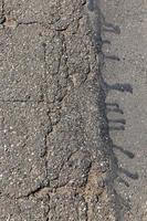 una strada asfaltata con molte buche e buche foto