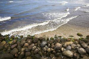 costa del mare con molte onde dal tempo ventoso foto