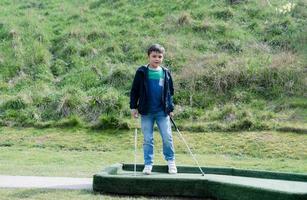 ritratto bambino attivo che gioca a minigolf nel parco, ragazzo carino che fa attività all'aperto giocando a golf pazzo nel campo primaverile, bambini che si divertono fuori con la famiglia in una giornata di sole d'estate foto