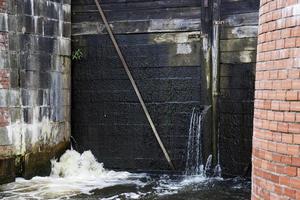 una parte che perde di una vecchia diga di legno foto