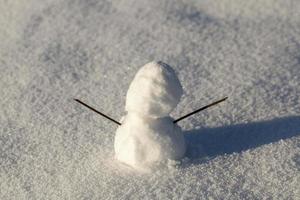 un piccolo pupazzo di neve nella stagione invernale, primo piano foto