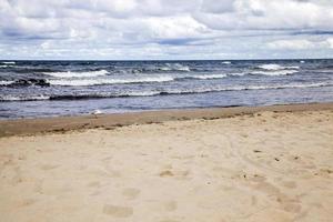 costa del mare con molte onde dal tempo ventoso foto