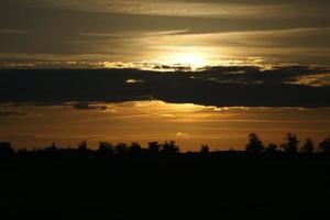 sole che tramonta alla periferia di berlino. il cielo sembra bruciare foto