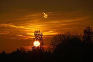 sole che tramonta alla periferia di berlino. il cielo sembra bruciare foto