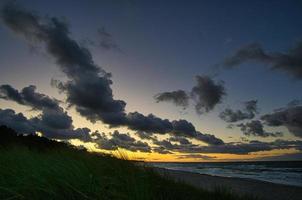 tramonto sulla costa baltica con nuvole nel cielo foto