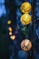 stringa di luci a forma di lampadina. festa in giardino o serata rilassante all'aperto. atmosfera leggera con bokeh foto