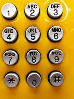 tastiera di numerazione del telefono grigia o grigia da premere per chiamare su sfondo giallo. foto