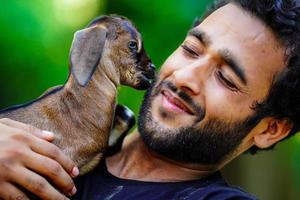 ragazzo con un simpatico animale domestico di capra foto