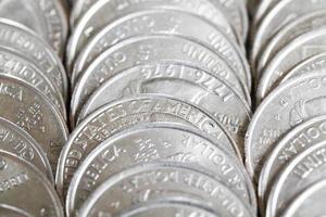 una pila di monete americane da venticinque cent, un primo piano di monete americane foto