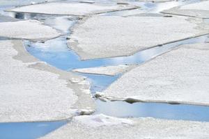 ghiaccio incrinato di fiume ghiacciato, acqua blu, struttura del ghiaccio foto