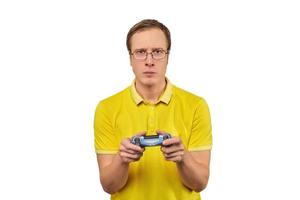 giocatore geek con gli occhiali e maglietta gialla con gamepad, giocatore di videogiochi eccitato isolato su bianco foto