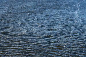 inquinamento della linea di schiuma nel fiume. emissioni di olio di fabbrica, inquinamento ambientale. fiume blu intenso con forte corrente. foto