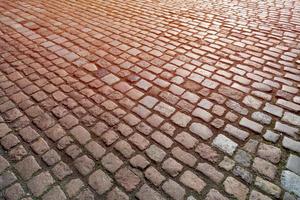 vecchio modello di pietre per lastricati. struttura dell'antico ciottolato tedesco nel centro della città. piccole piastrelle di granito. pavimenti grigio antico. foto